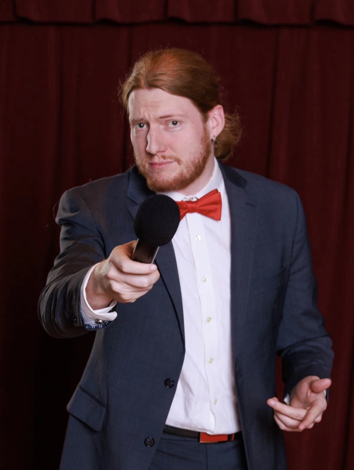 Comic cabaret host pointing toward the audience