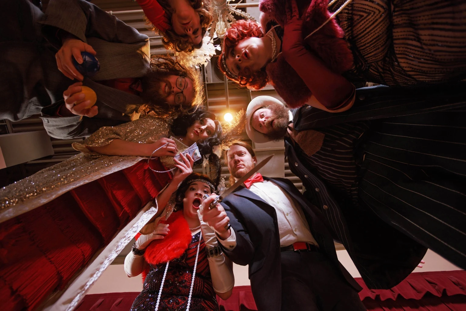 The murder mystery cast looking down at the audience during a dramatic comic scene